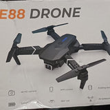 Black quadcopter drone with camera, four foldable propellers and visible camera housing