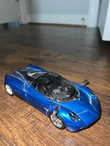 Blue 1/24 scale diecast model toy car with black hood and silver wheels
