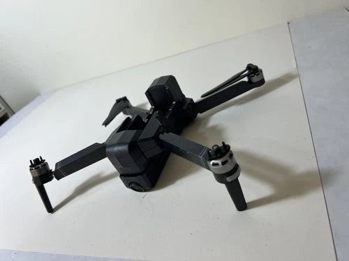 Black quadcopter drone body with four propeller arms and camera housing