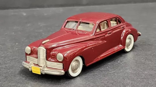 Red diecast classic car model with chrome grille and whitewall tires, front 3/4 view