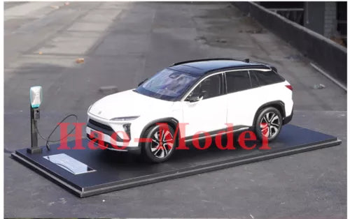 White alloy diecast car model with blue windows and red wheel accents