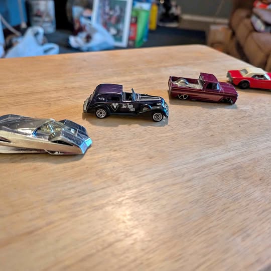 1/64 scale diecast toy cars, assorted colors, on wooden surface