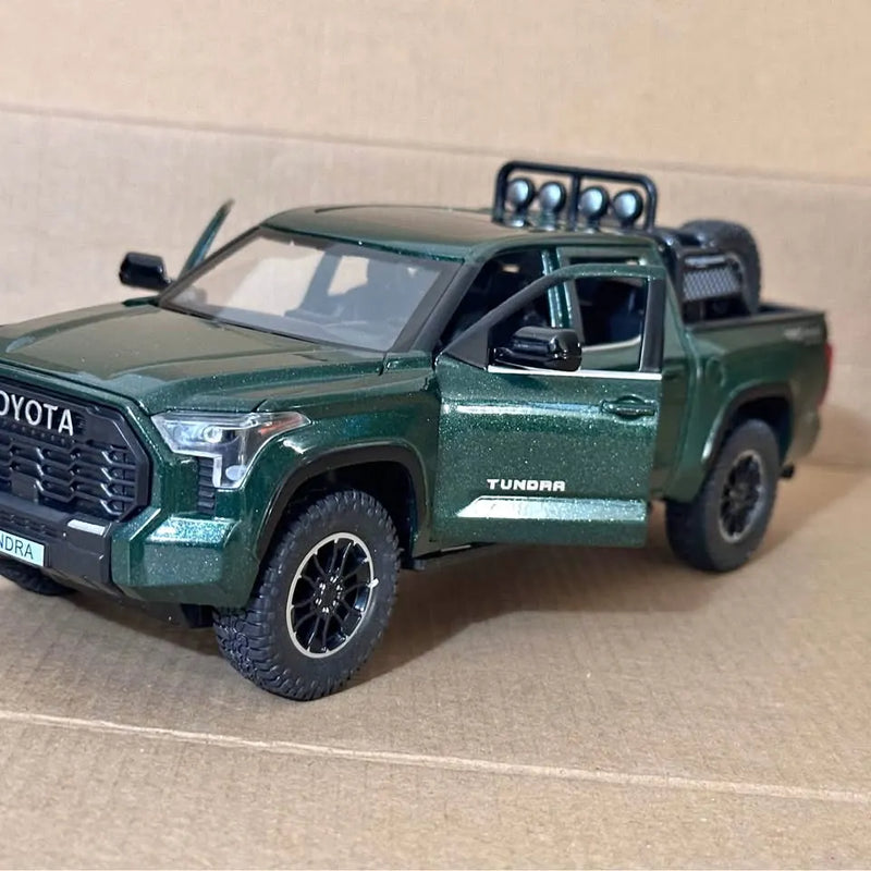 Green 1:24 diecast pickup truck with roof light bar and Tundra door badge