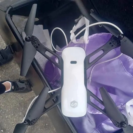 White drone camera with four propeller arms, visible front control module