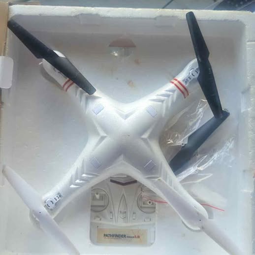 White quadcopter drone with four black propellers and spare blades