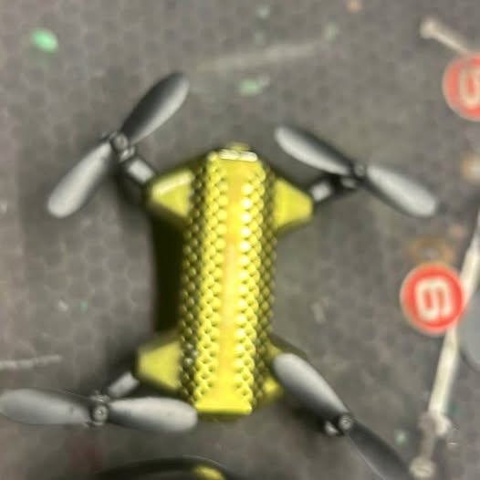 Two mini drones with yellow bodies and four propellers each