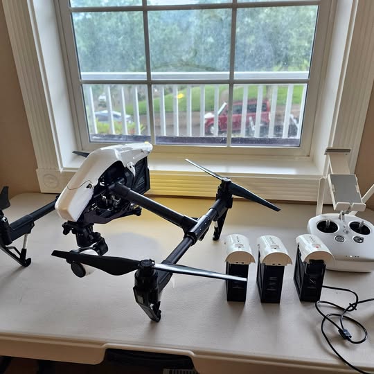 DJI Inspire 1 V2 drone with four propellers, white body, on work surface