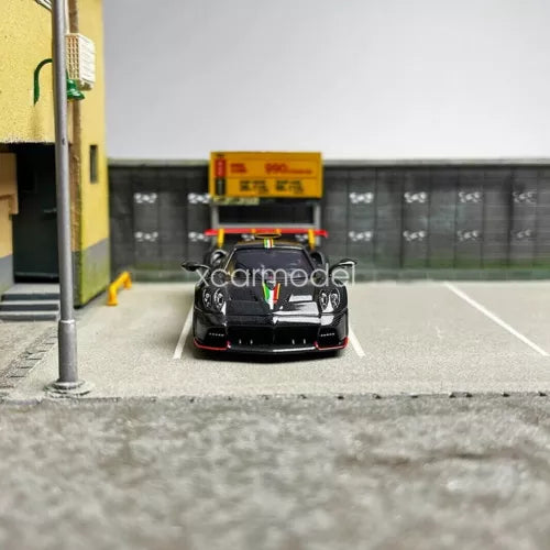 Black 1/64 diecast sports car model, front view with detailed grille and headlights