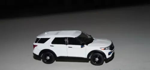 White police SUV diecast toy car, black roof and wheels, 3/4 front view