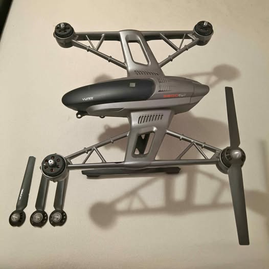 Dark gray quadcopter drone body with four motors and landing legs