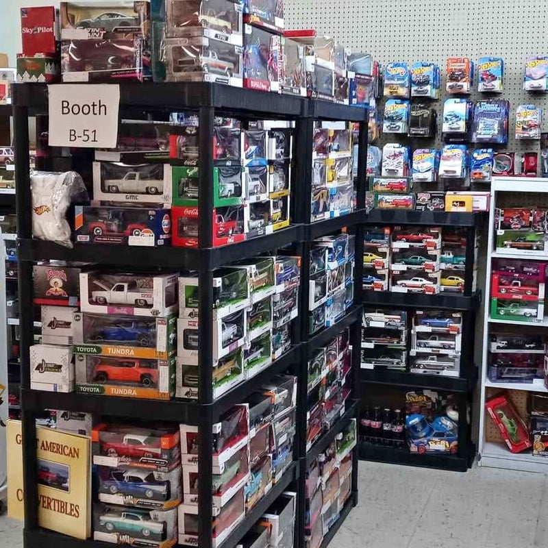 Diecast cars and trucks display shelf with boxed vehicles, multiple colors