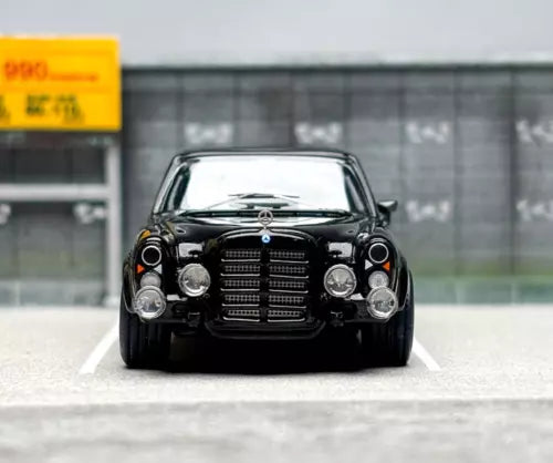 Black diecast sedan car toy, front view with grille and headlights
