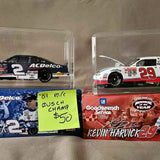 Diecast racing car set in display cases, black #2 and red #29, signed style.