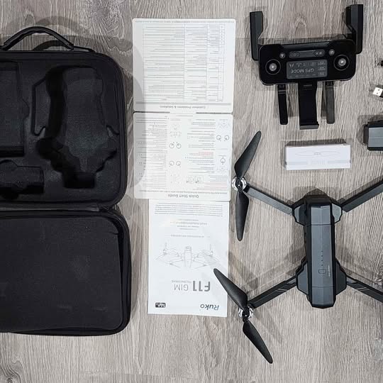 Ruko F11GIM drone with controller, carrying case, and instruction papers