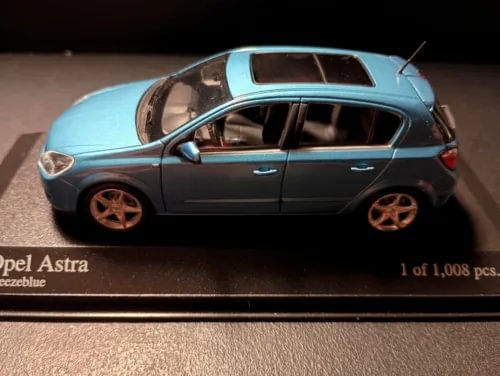 Light blue and dark gray 1:43 diecast car model, side view with alloy wheels