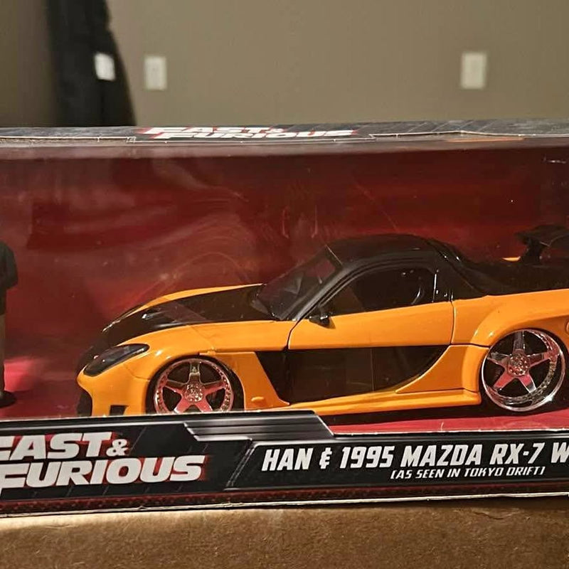 Orange and black diecast model car with rear wing and chrome wheels