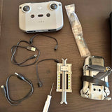 White DJI drone with controller unit and cables, prop tool and protective bag