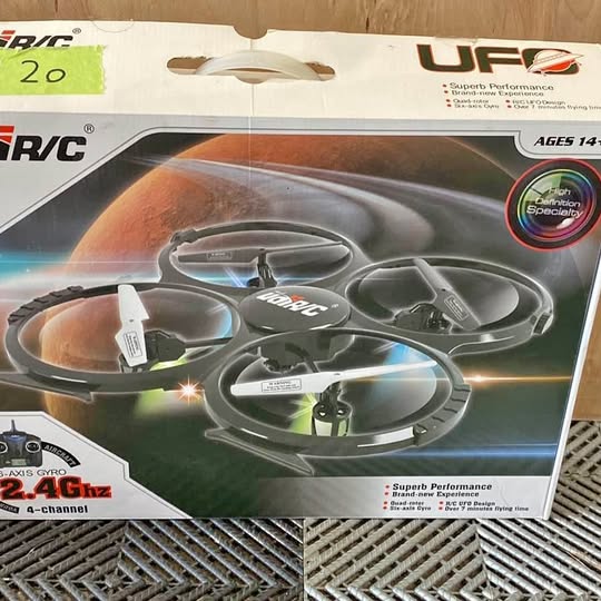 RC drone toy in retail box, gray quadcopter with propellers visible through window