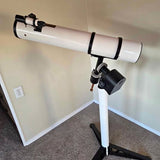 Astronomer telescope with white tube and black eyepiece mount on tripod