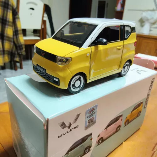 Yellow Wuling MiniEV diecast model car with black hood, on box