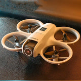 Cream mini quadcopter drone with front camera and four propellers
