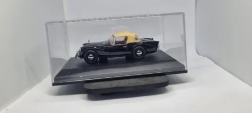 1:43 scale model sports car with raised hood, black and yellow, in display case