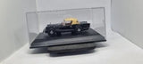 1:43 scale model sports car with raised hood, black and yellow, in display case