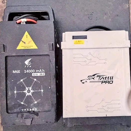 Drone battery pack, black and white with wiring ports and printed labels