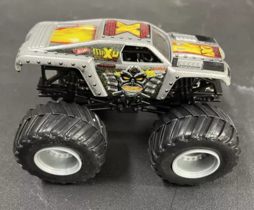 Gray diecast monster truck with oversized black tires and racing graphics, yellow accents