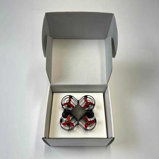 Mini quadcopter drone in open box with four propellers