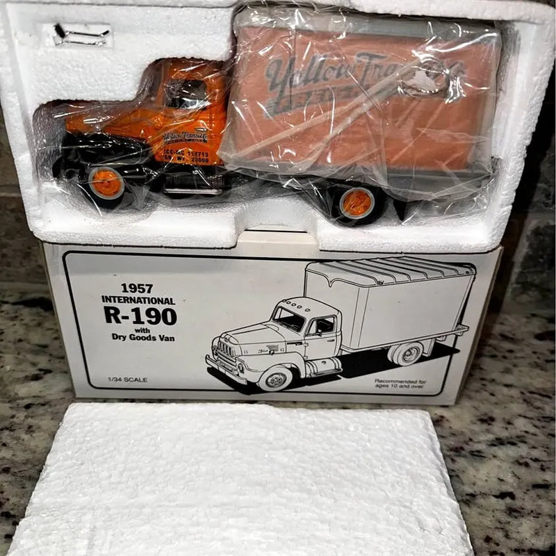 Diecast freight truck model in box, orange cab and trailer, plastic-wrapped 1:34.
