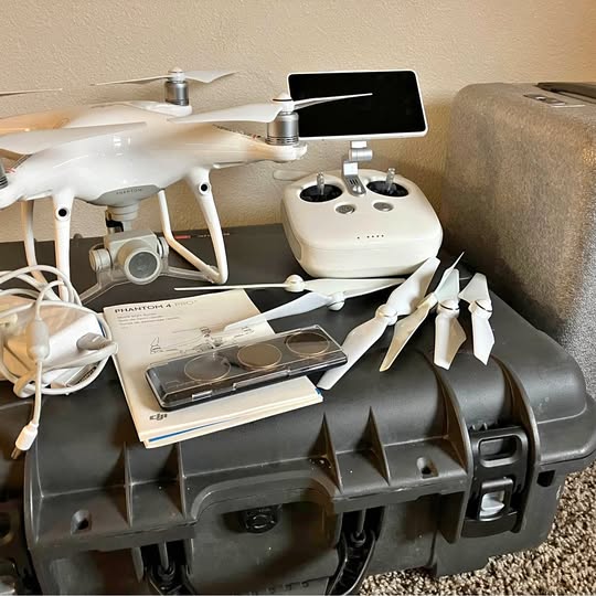 White quadcopter drone with remote display and propellers, controller and accessories