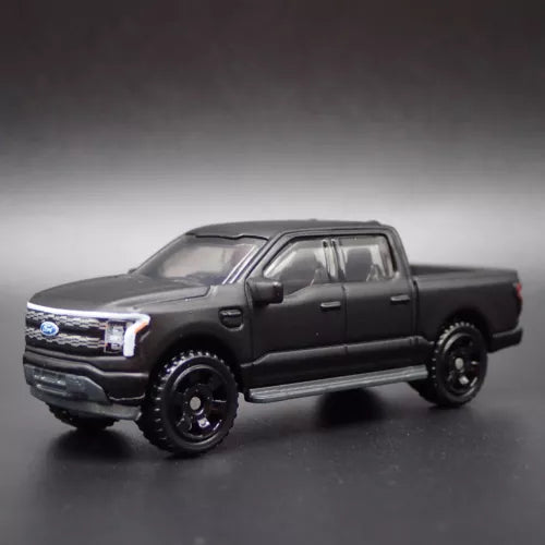 1:64 diecast pickup truck model, dark color, front three-quarter view