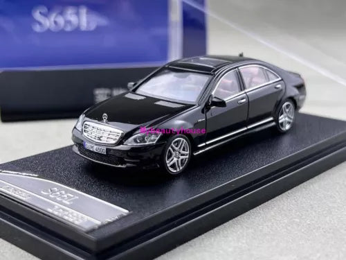 Black diecast metal sedan sports model toy car, front three-quarter view on base