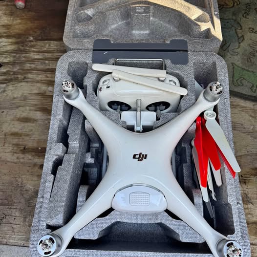 White DJI Phantom 4 drone in open protective case, front view with landing feet