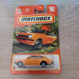 Orange 1:64 diecast car model in Matchbox blister pack, front view.