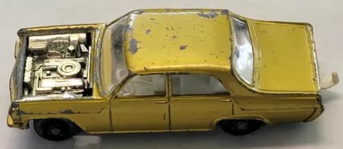 Yellow vintage diecast car with hood open, engine visible, four-door body