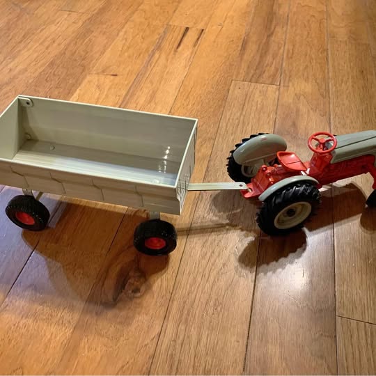 Red diecast Ford tractor with mint wagon and black wheels
