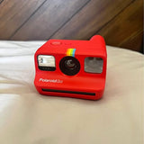 Red Polaroid Go instant camera with front lens and flash