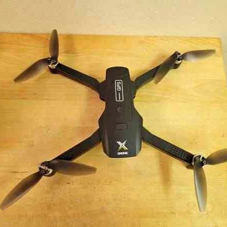 Black quadcopter drone with four propellers and central body module