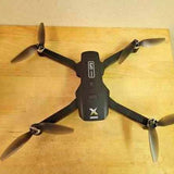 Black quadcopter drone with four propellers and central body module
