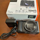 Black compact digital camera with large zoom lens and textured grip