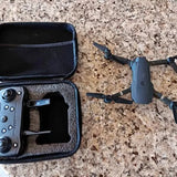 Foldable drone with camera, plus blue-cased controller in a black carrying case