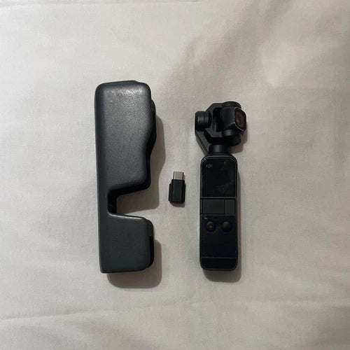 Handheld action gimbal camera with black grip and small accessory pieces