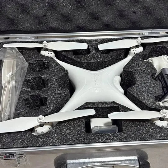White quadcopter drone with 4 propellers in foam-lined hard case
