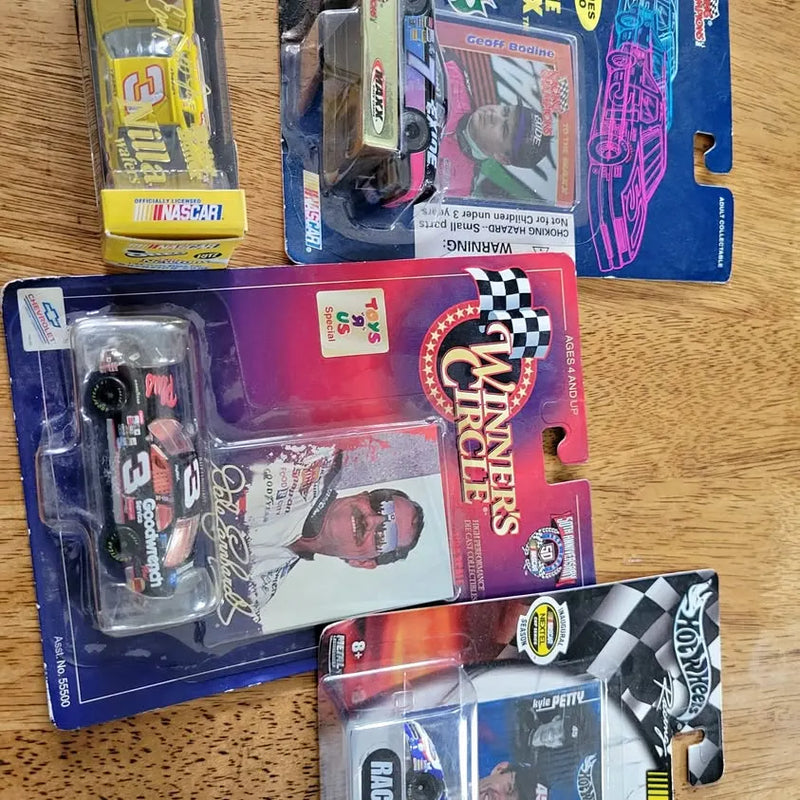 1:64 NASCAR diecast race car in blister pack with checkered flags