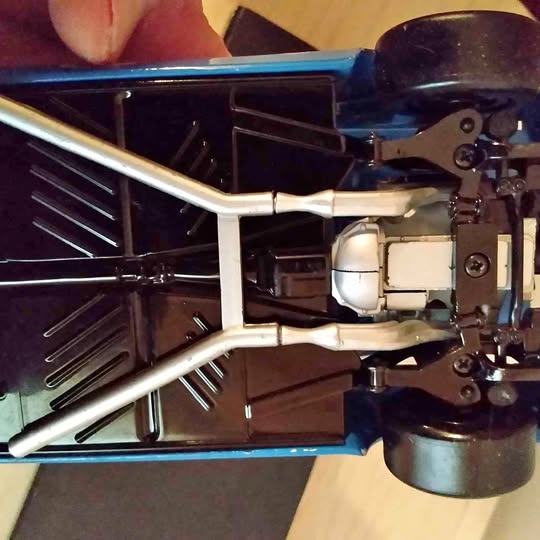 Diecast racing car model with exposed metal chassis and front wheels