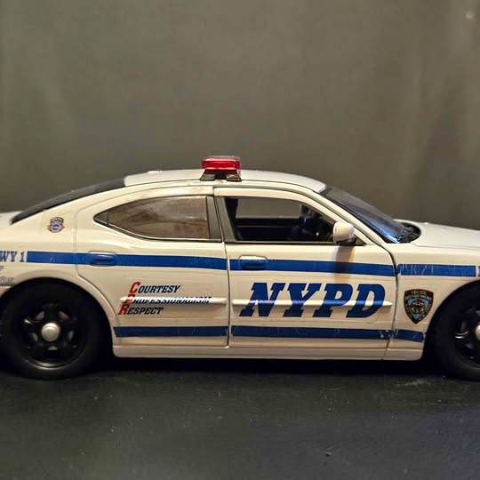 NYPD diecast police car model, white with blue stripes and roof light