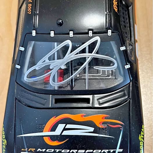 Signed 1:24 diecast race car with JRM Motorsports logo and blue autograph on windshield