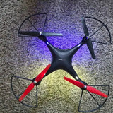 Black quadcopter drone with red propeller blades